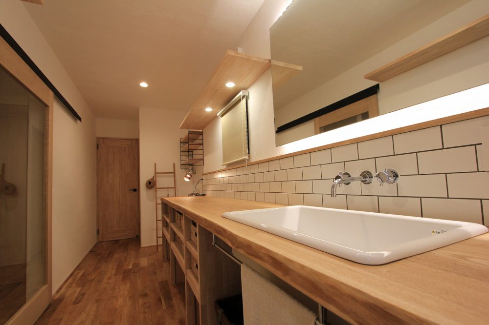洗面室の天板に木を使い、優しい雰囲気に。床もオークの無垢材で木の温もりあふれる空間に。